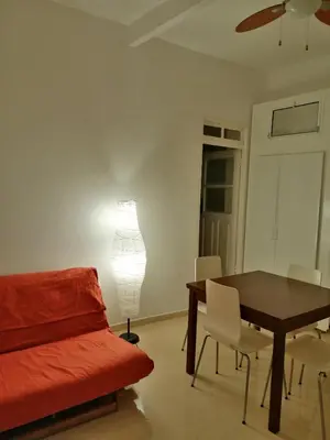 a living room with a table and a lamp at Casas do Cinema I in Mindelo