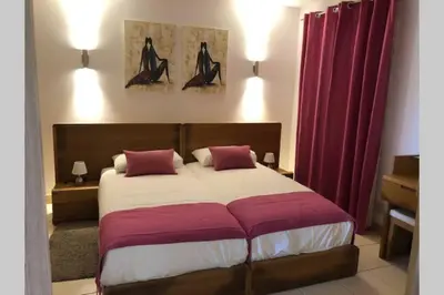 a bedroom with a large bed with red curtains at Schönes, ruhiges und geräumiges Apartment mit Poolanlage in der Nähe von Santa Maria in Prainha