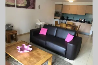 a living room with a black leather couch and a table at Schönes, ruhiges und geräumiges Apartment mit Poolanlage in der Nähe von Santa Maria in Prainha