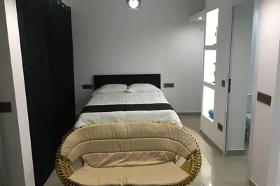 a bedroom with a bed and a chair at Studio GARAGE in Mindelo