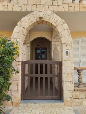 an entrance to a building with a wooden gate at Comfortable and spacious apartment with ocean views of Cabral beach in Sal Rei
