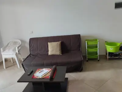 a living room with a brown couch and a table at Comfortable and spacious apartment with ocean views of Cabral beach in Sal Rei