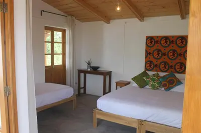 a bedroom with two beds and a window at La Fora Ecolodge in São Filipe