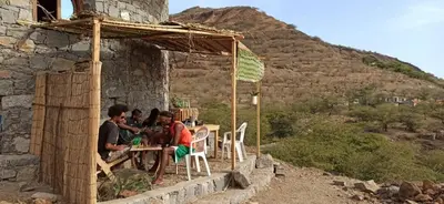 a group of people sitting at a table outside a building at Casa Fabrice in Ribeira da Prata