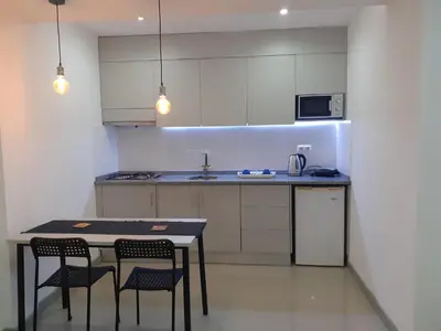 a kitchen with a table and chairs and a microwave at Apto T1 Sweet Home in Praia