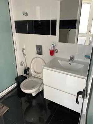 a bathroom with a white toilet and a sink at Bellamy in Porto Novo