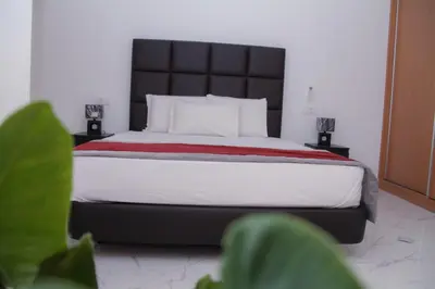 a bedroom with a large bed with a black headboard at Hotel Por Do Sol in Tarrafal