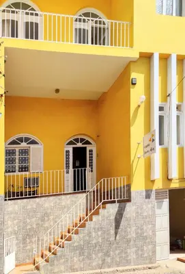 a yellow building with stairs in front of it at Casa Bom Dia in Mindelo