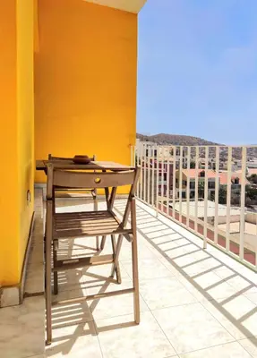 a wooden table on a balcony with a view at Casa Bom Dia in Mindelo