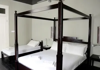 two bunk beds in a room with white sheets at Casa Colonial in Mindelo