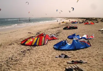 a group of kites on a beach with people flying kites at Ibiscus in Santa Maria