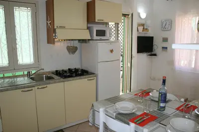 a small kitchen with a table and a white refrigerator at Ibiscus in Santa Maria