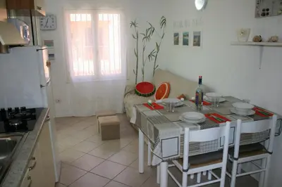 a kitchen with a table and a kitchen with a refrigerator at Ibiscus in Santa Maria
