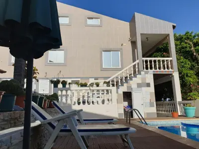 a pair of lounge chairs on a deck with a building at Cactus Guest House in Cidade Velha