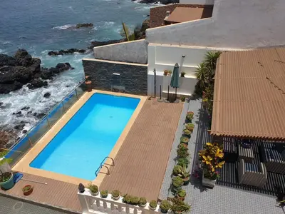 an overhead view of a swimming pool next to the ocean at Cactus Guest House in Cidade Velha