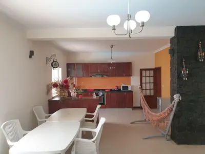 a living room with a table and chairs and a kitchen at Cactus Guest House in Cidade Velha