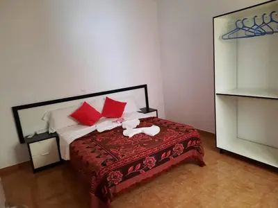 a bedroom with a bed with red and white pillows at FRANMAY APARTMENTS - 7 modern apartments near the beach & city in Santa Maria