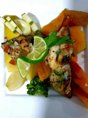 a white plate of food with chicken and vegetables at Txon DFogo Pensão Restaurante in São Filipe