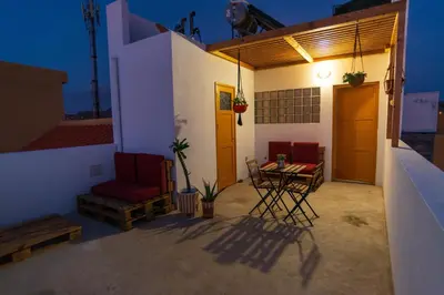 a patio with two chairs and a table on a house at Apartamento Zinha Amwilla Guesthouse in Mindelo