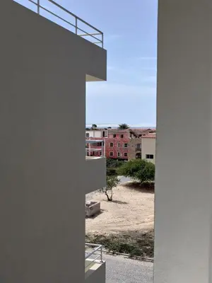 a building with a view of a courtyard with buildings at Rosa dei Venti Apartment 50meter beach front in Sal Rei