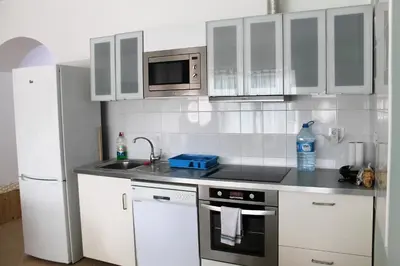 a kitchen with white cabinets and a sink and a refrigerator at African Sunset in Sal Rei