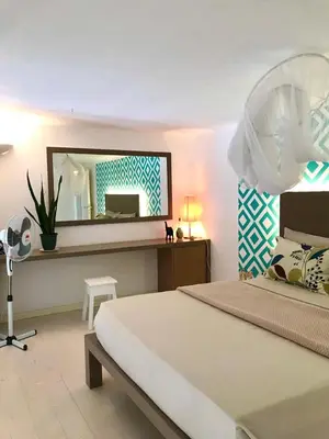 a bedroom with a large bed and a mirror at App Rosanna, Estoril Beach, 2steps from the sea, Free Wi-Fi & AC in Sal Rei