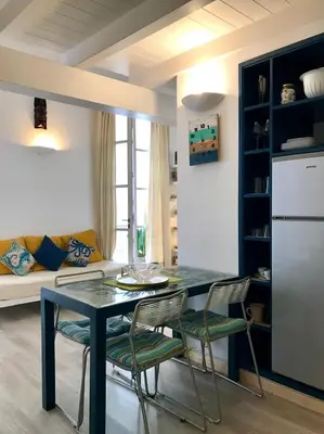 a kitchen with a table and chairs and a couch at App Rosanna, Estoril Beach, 2steps from the sea, Free Wi-Fi & AC in Sal Rei