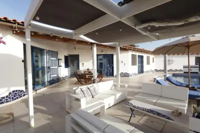 a patio with white couches and an umbrella at L' Ancora - Room With Exclusive Pool And Terrace in Palmeira