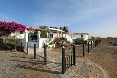 a fence in front of a house with flowers at L' Ancora - Room With Exclusive Pool And Terrace in Palmeira