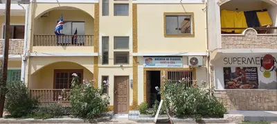 a yellow building with an american flag on a balcony at Ka-Bela 2 in Sal Rei