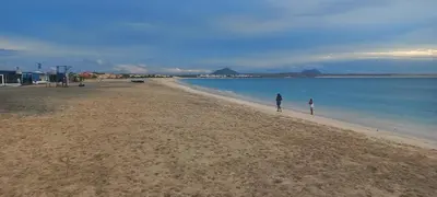 two people walking on a beach near the water at Ka-Bela 2 in Sal Rei