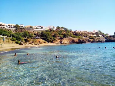 a group of people swimming in the water at a beach at Apto Morabeza T2 Praia in Praia