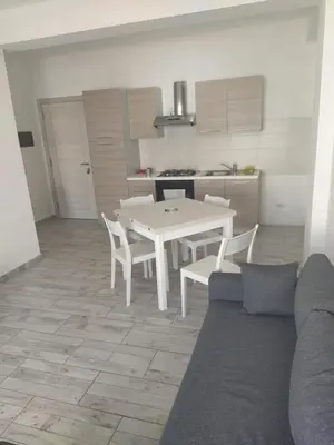 a living room with a table and chairs and a kitchen at Ca'Claudia Boavista in Sal Rei