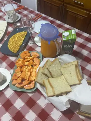 a table with a plate of bread and eggs and toast at Rose`s place in Mindelo