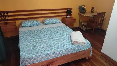 a bedroom with a bed with a blue comforter and a desk at Rose`s place in Mindelo