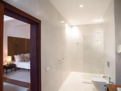 a bedroom with a bed and a bathroom with a shower at Casa da Djedja in Mindelo