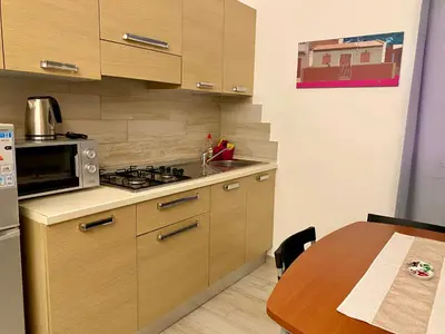 a kitchen with a stove and a wooden table at Ca GIOgió in Santa Maria