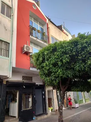 a red building with a tree in front of it at Cesária Évora Loft in Praia