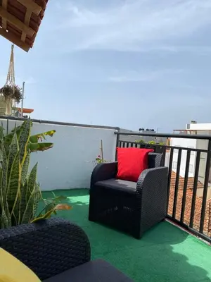 a black chair with a red pillow on a balcony at Christian Place in Praia