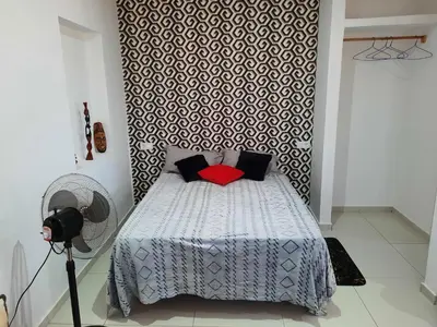 a bedroom with a bed with a black and white patterned wall at Guest House Maio in Vila do Maio