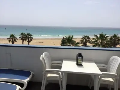 a table and chairs with a view of the beach at Leme Bedje GST84 3 bedroom apt with Panaramic views in Santa Maria