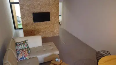a living room with a couch and a tv on a wall at Urban Sal Loft in Espargos