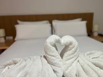 a white bed with two swans forming a heart at Hotel Vista in Praia
