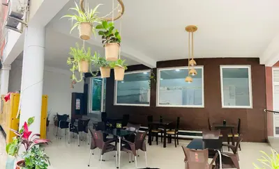 a dining room with tables and chairs and potted plants at Hotel Vista in Praia