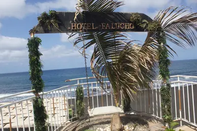 a sign for a hotel on the beach at Falucho Paradise Beach in Pedra Badejo