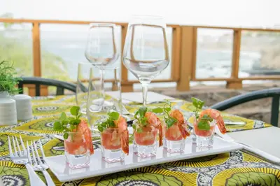 a tray of food on a table with wine glasses at Oasis Praiamar in Praia