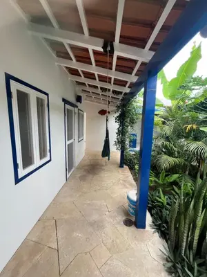 a hallway of a house with blue columns and plants at Quintal do Maio in Vila do Maio