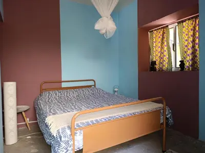 a bedroom with a bed in a blue room at Ecolodge Ribeira Principal in Xá Xá