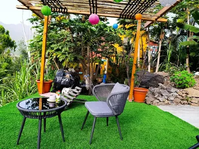 a patio with two chairs and a table on grass at Ecolodge Ribeira Principal in Xá Xá