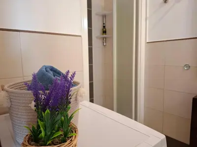 a basket of purple flowers sitting on a table in a bathroom at Sunset house Cabo Verde in Santa Maria